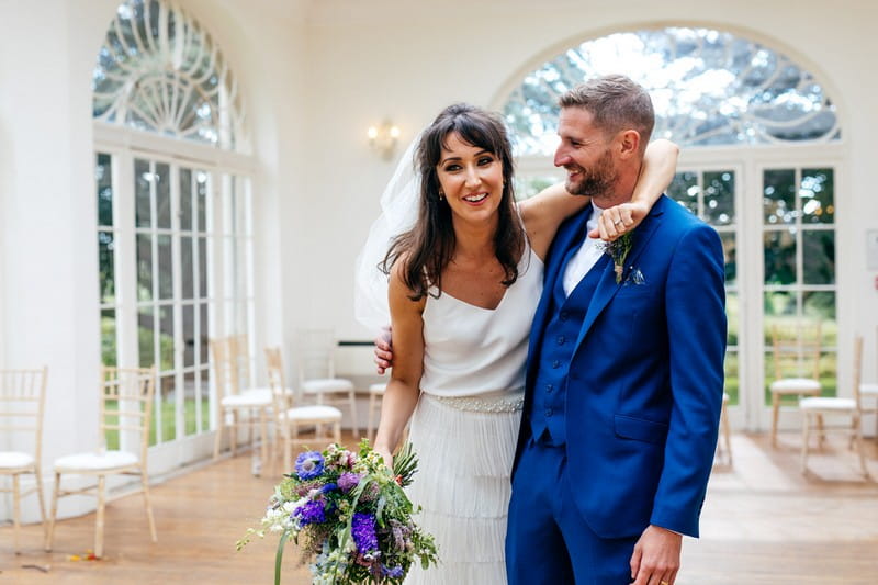 Bride with arm around groom's shoulders