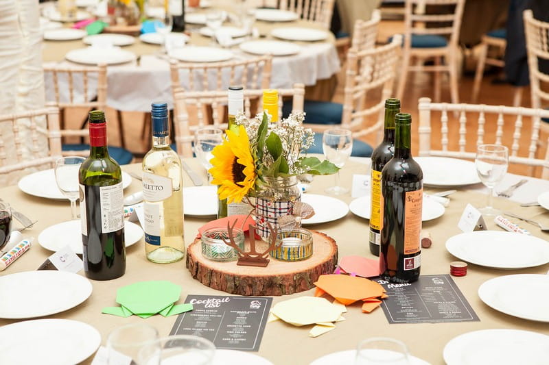 Sunflower in jar on top of log slice on wedding table