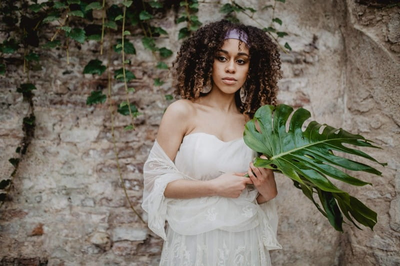Bride holding large tropical palm leaf