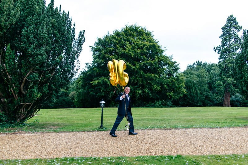 Man carrying balloons to wedding ceremony