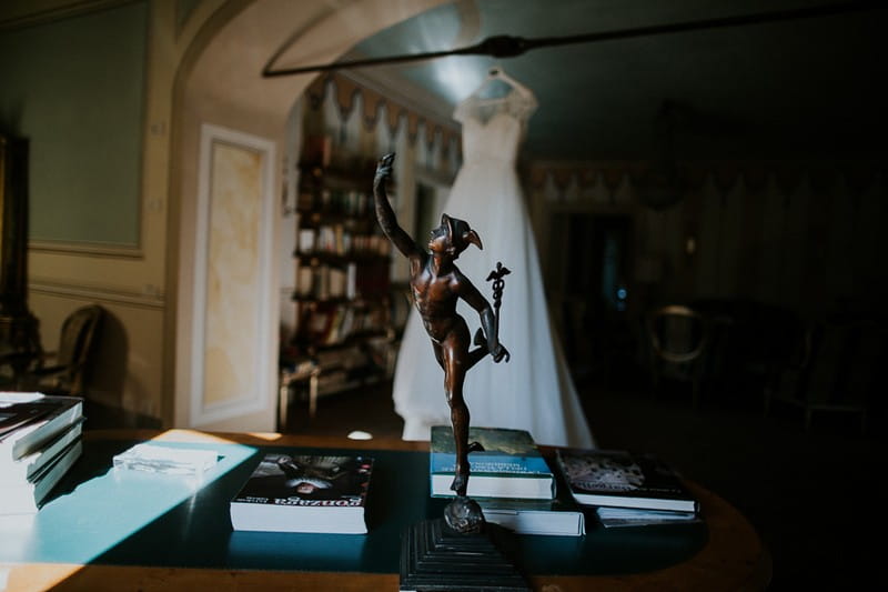 Desk statue in front of hanging wedding dress