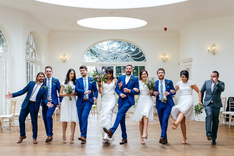 Bridal party dancing with arms linked at Barton Hall