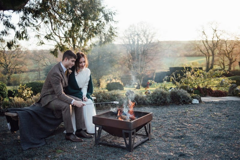 Bride and groom toasting marshmallows on fire