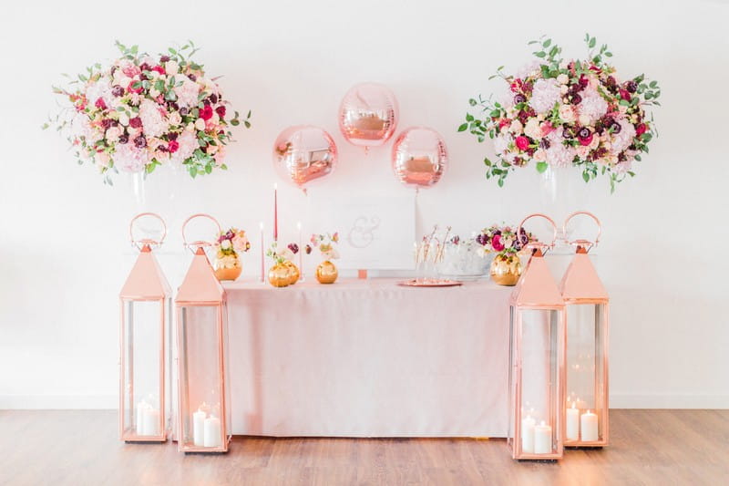 Engagement party welcome table styled with pink and metallic items