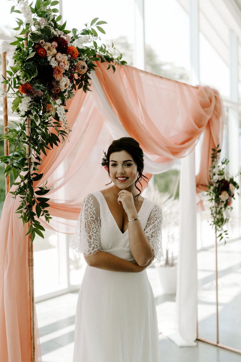 Bride standing in front of pink fabric backdrop