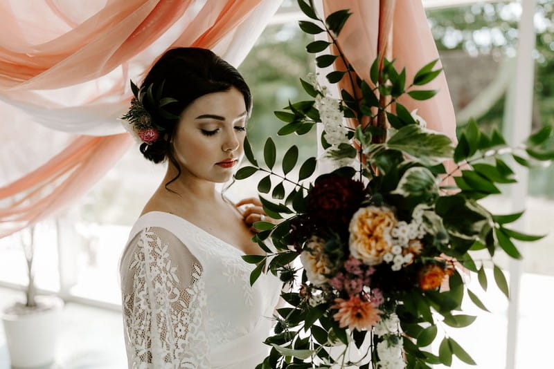 Bride standing by winter wedding floral display