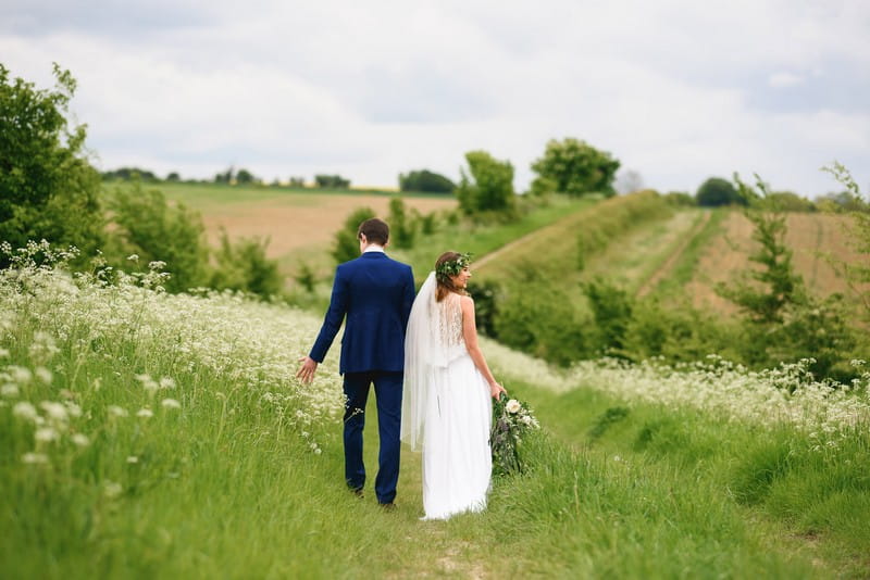Bride and groom walking in countryside - Picture by Sam Gibson Photography