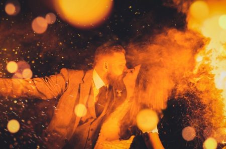 Bride and groom kissing amongst smoke and sparks from flares - Picture by Lilly Sells Photography