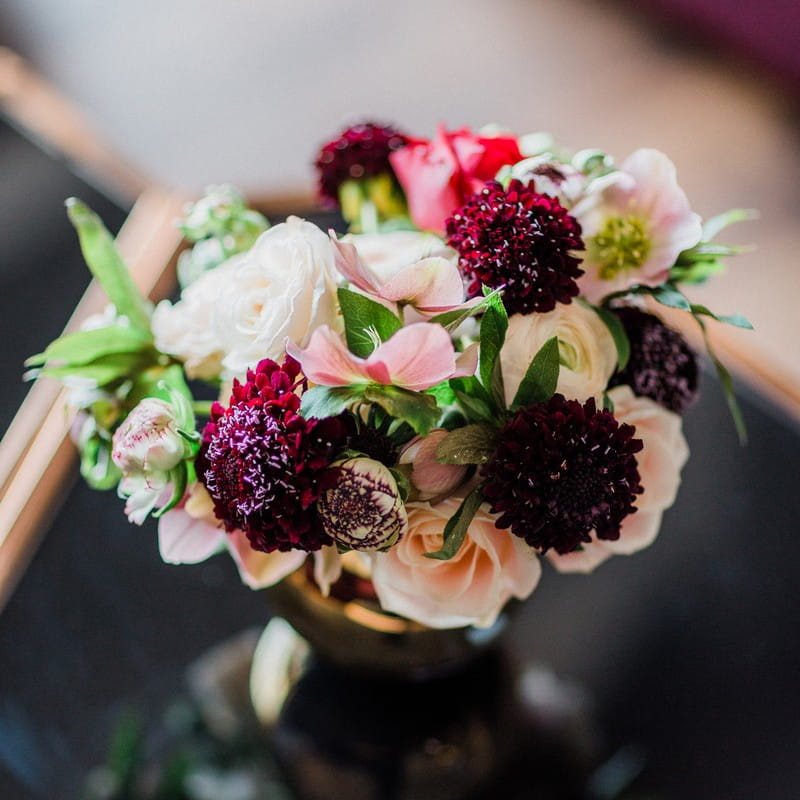 Small vase of pink and dark red flowers