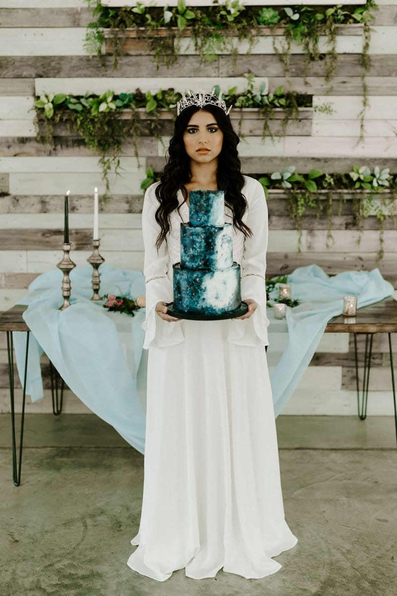 Bride holding blue celestial style wedding cake