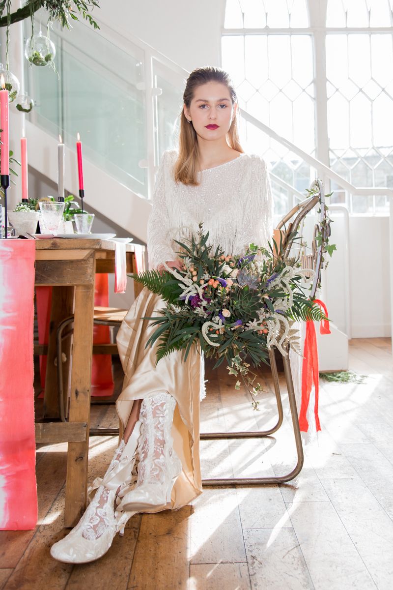 Bride sitting at wedding table holding bouquet