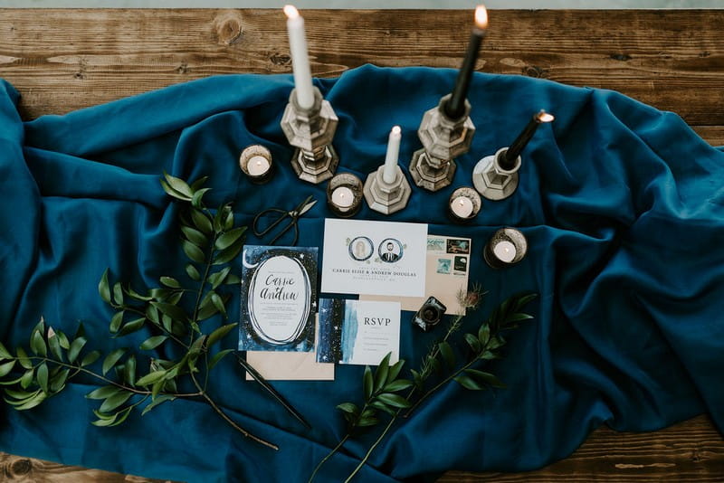 Blue celestial wedding stationery and candles on blue cloth