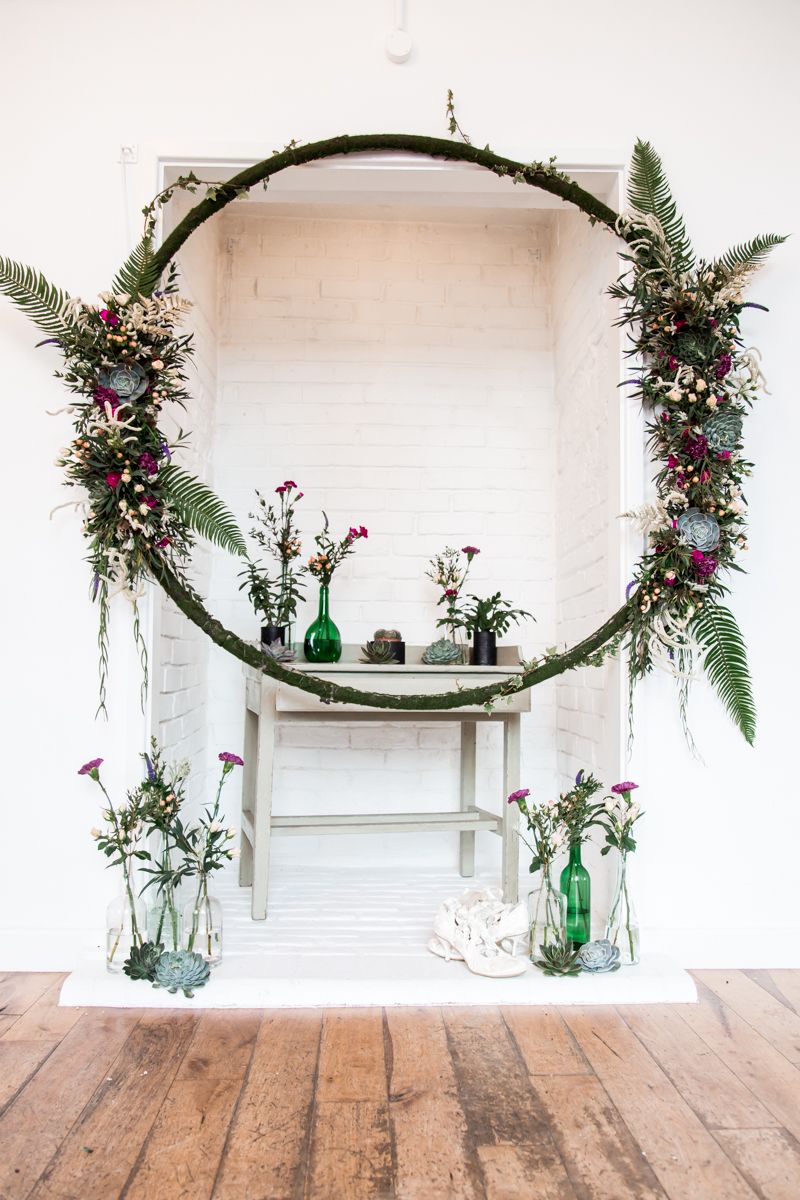 Wedding ceremony display with floral hoop and vases of flowers