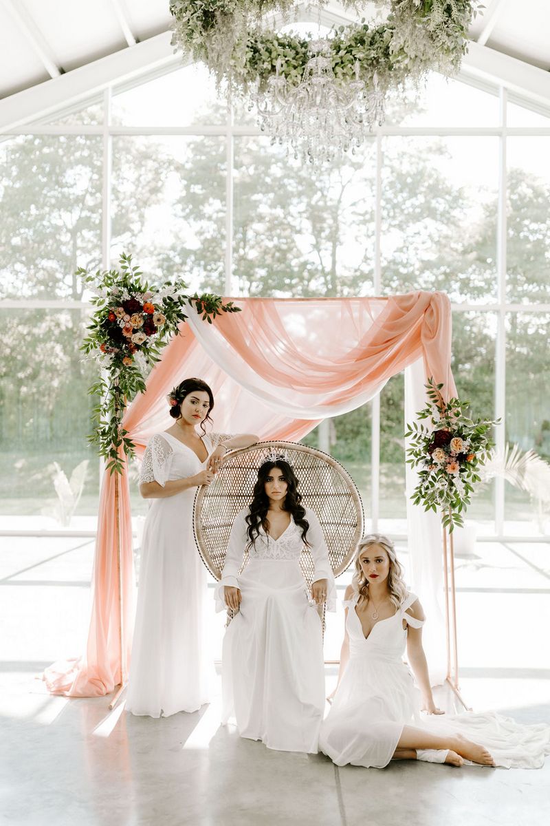 Three brides in front of ceremony backdrop