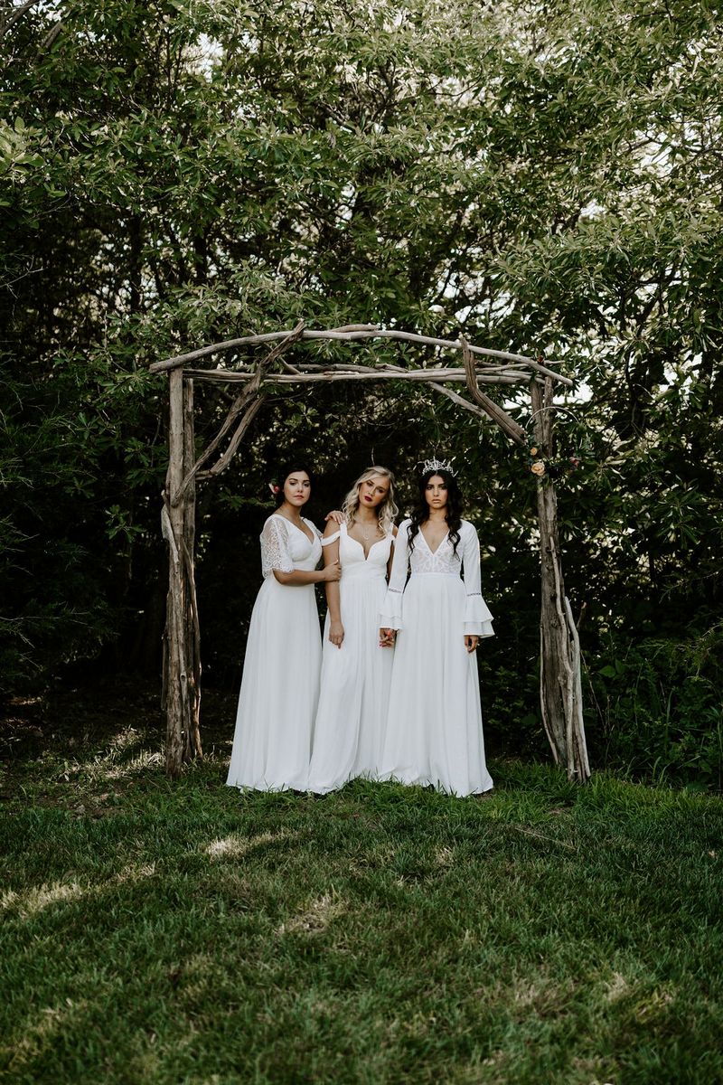 Brides in front of wooden structure in grounds of Greenhouse Two Rivers