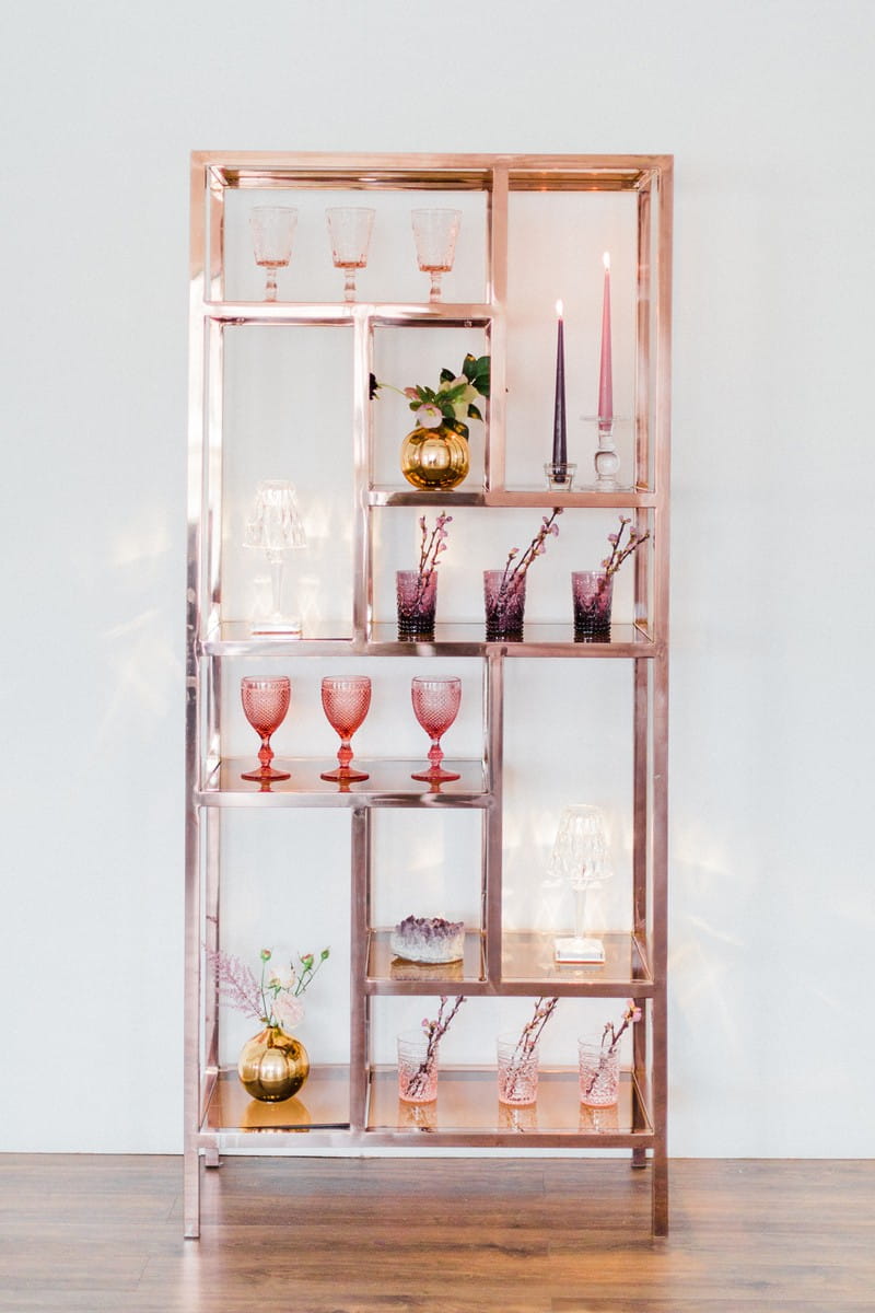 Rose gold shelving unit with styling items for engagement party