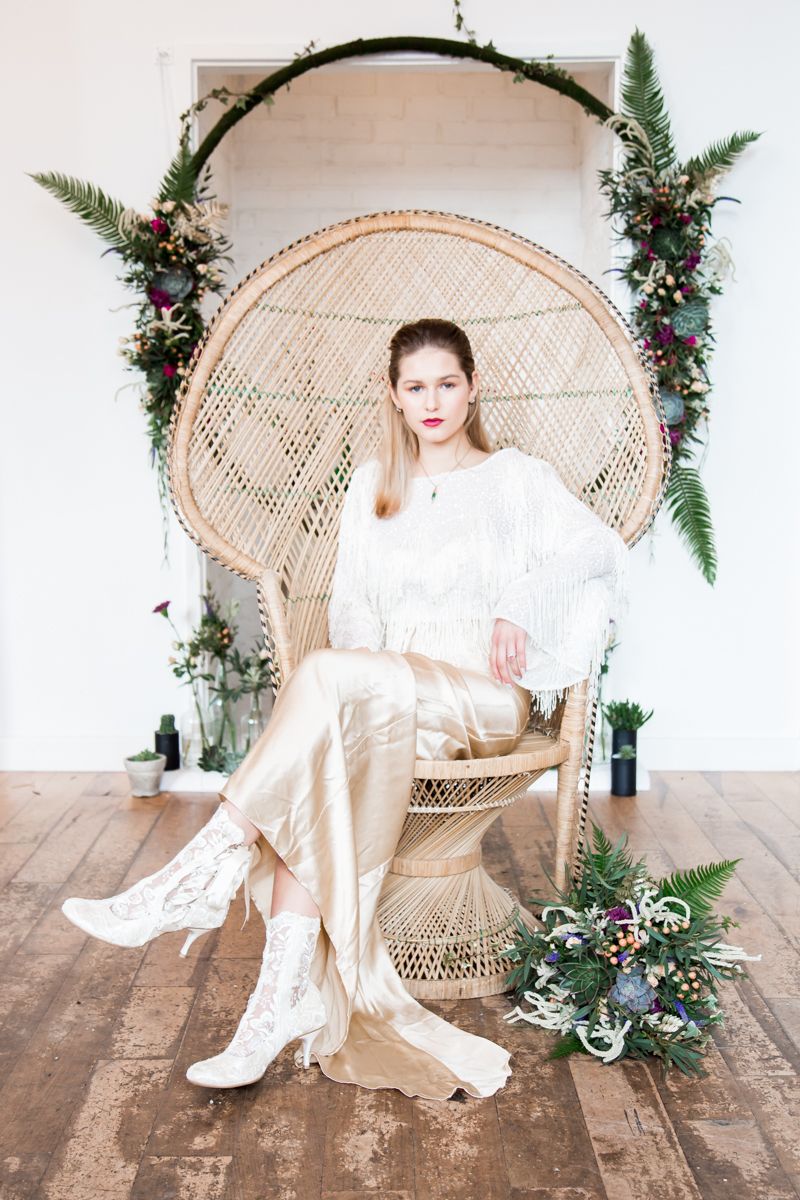 Bride sitting in vintage peacock chair