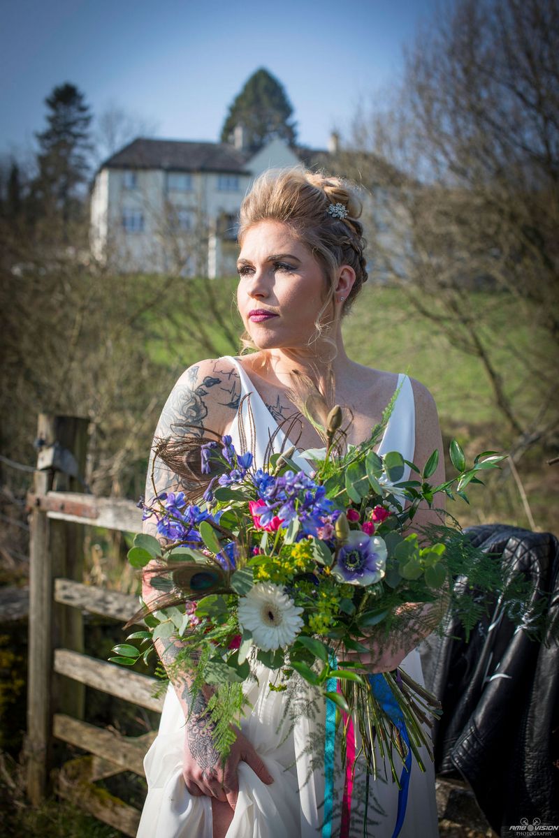 Bride holding rustic bouquet in countryside