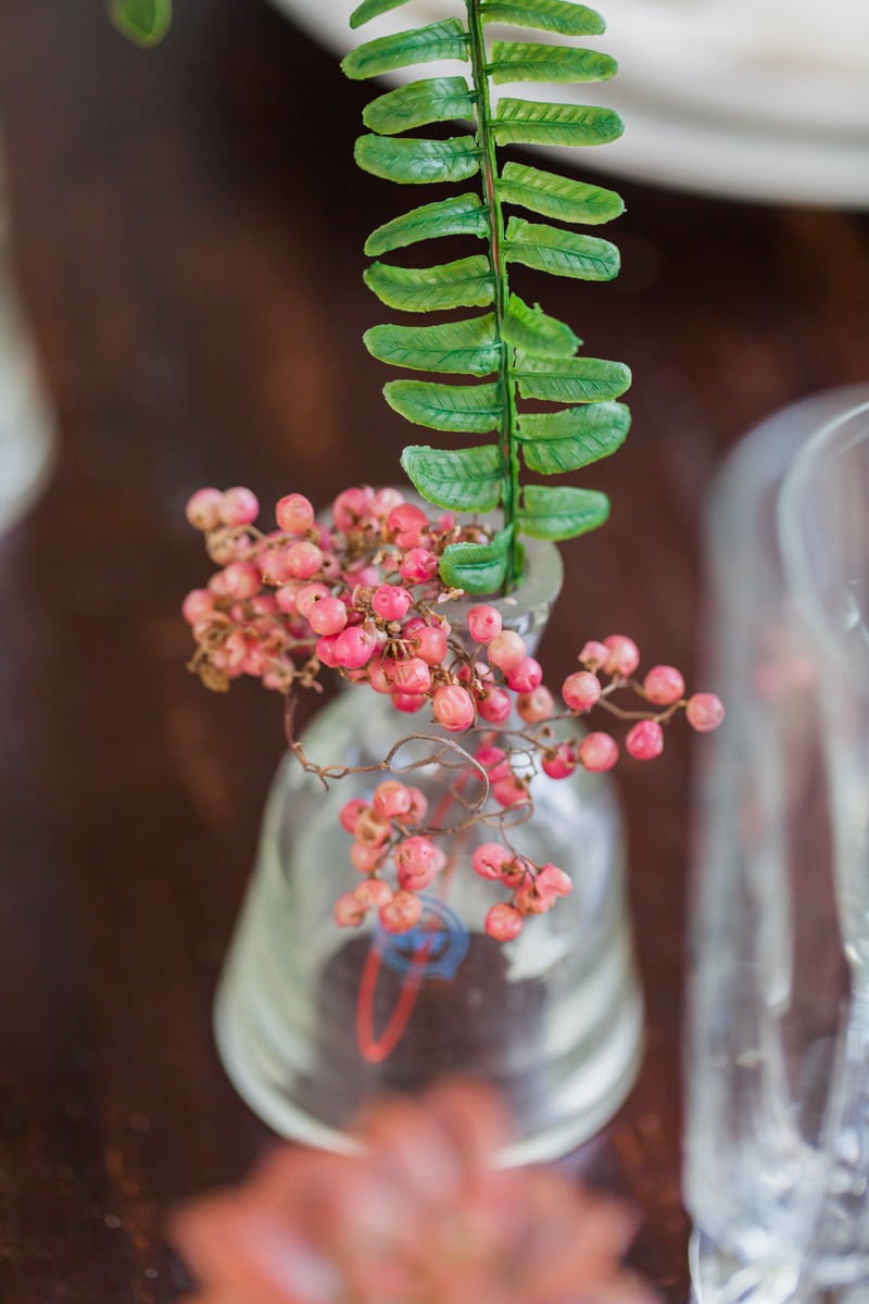 Small red berries in vase on wedding table