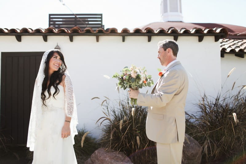 Bride turning to see groom holding bouquet