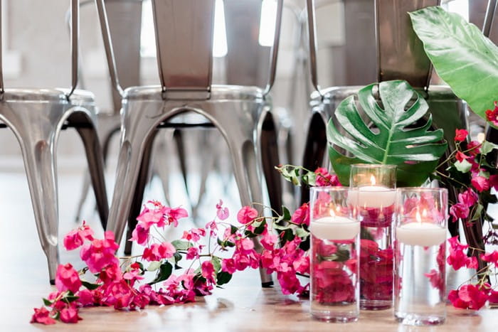 Pink bougainvillea on floor with vases of floating candles
