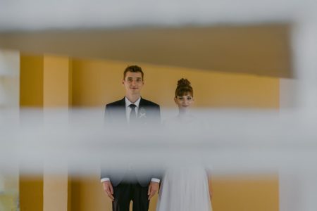 Picture of bride and groom standing next to eash other taken through slats in blind - Picture by Rares Ion