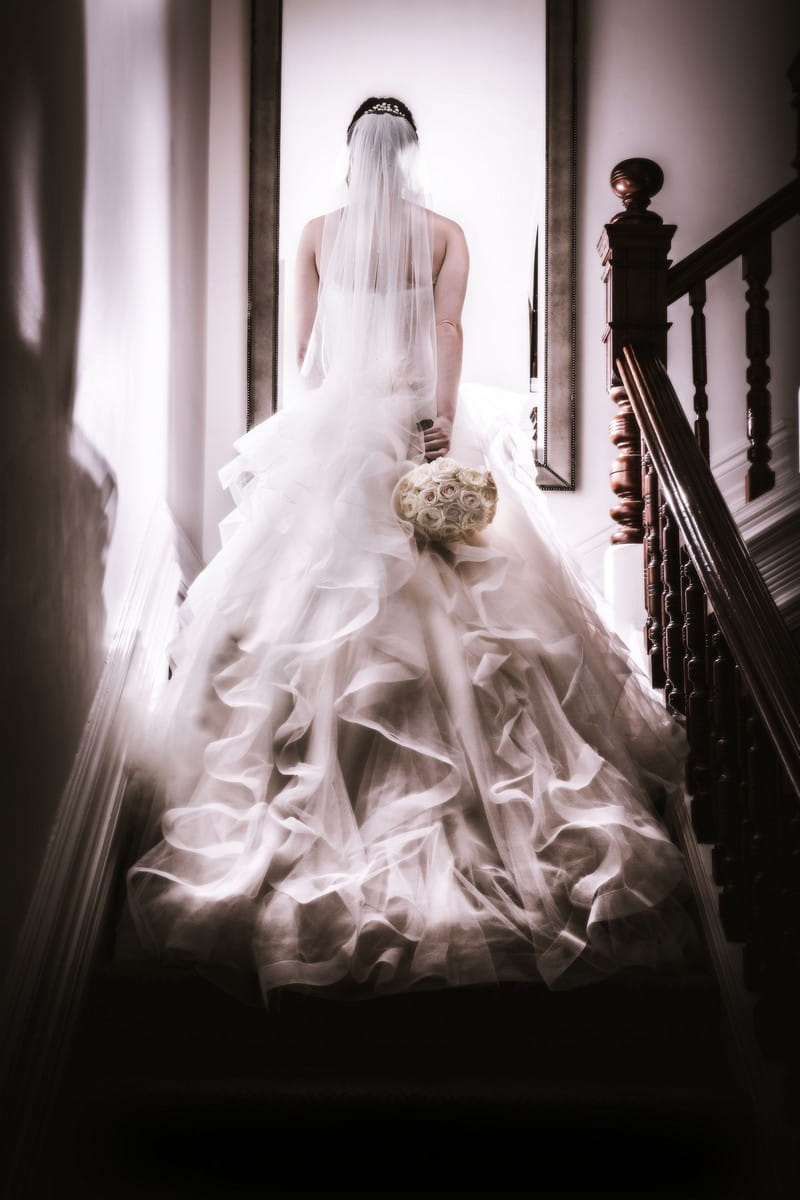 Bride walking up staircase - Picture by Peter Rollings Photography