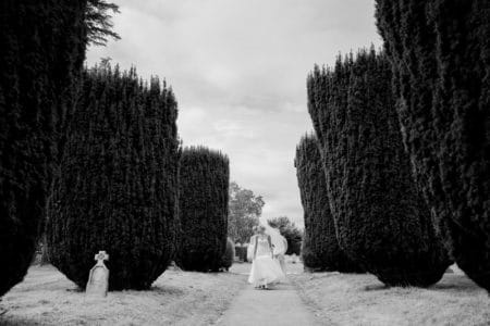 Bride walking down path past bushes to wedding ceremony - Picture by Joss Denham Photography