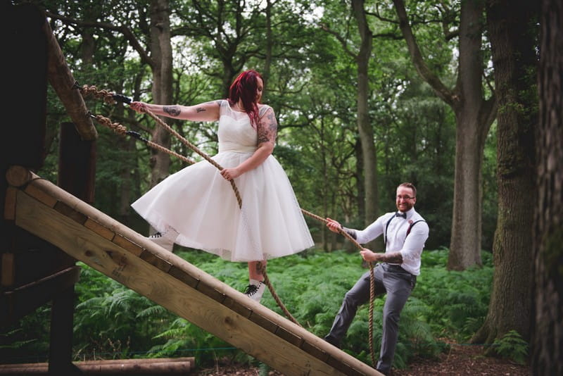 Bride and groom holding onto ropes on assault course obstacle - Picture by Nick Brightman Photography