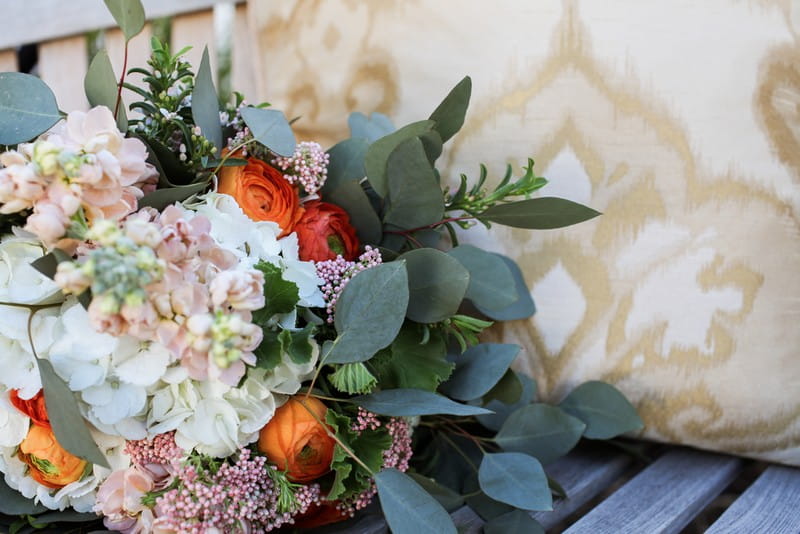 Bridal bouquet with orange and white flowers and green leaves