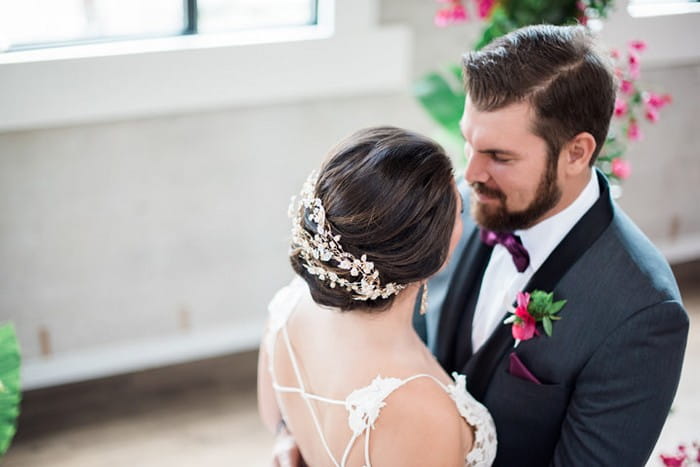 Bride with floral hair accessory facing groom