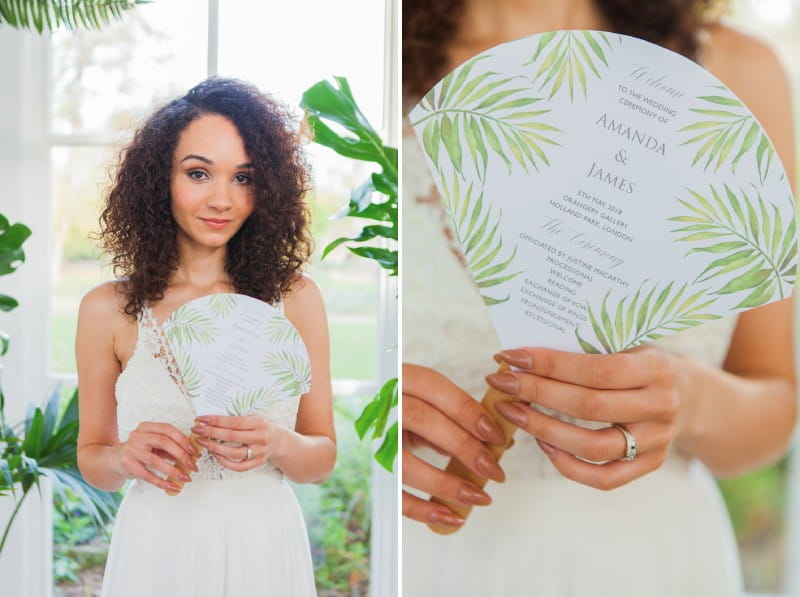 Bride holding wedding order of service fan with tropical leaf design