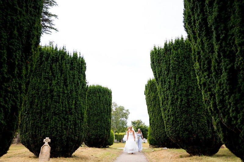 Bride walking down path to church