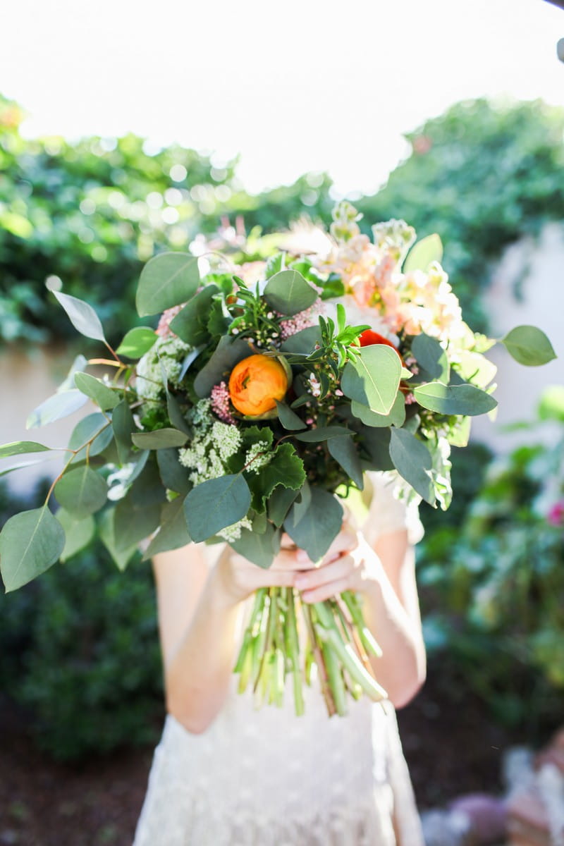 Flower girl holding bouquet in front of her face