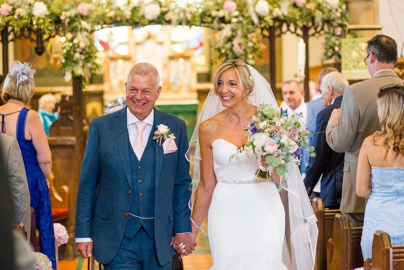 Bride and groom smiling as they leave church after wedding ceremony