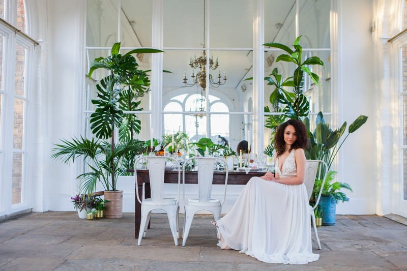 Bride sitting at wedding table in Holland Park Orangery