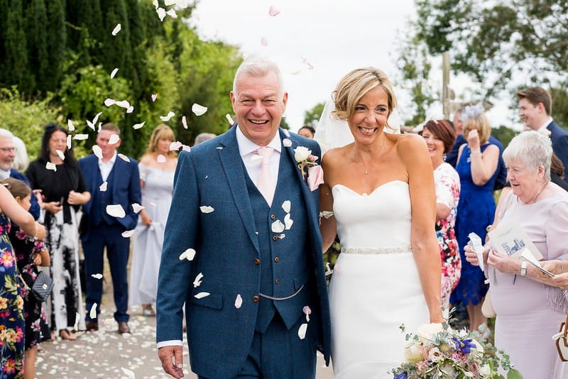 Bride and groom being showered with confetti after wedding ceremony