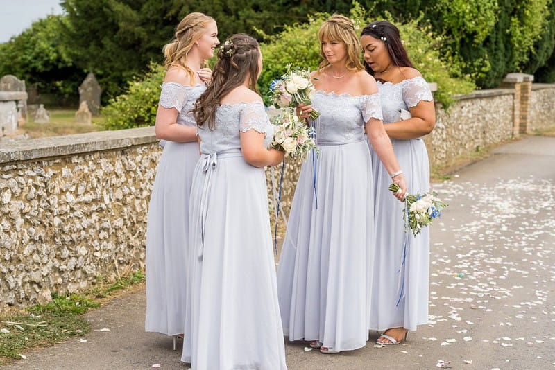 Bridesmaids outside church wearing blue/grey dresses