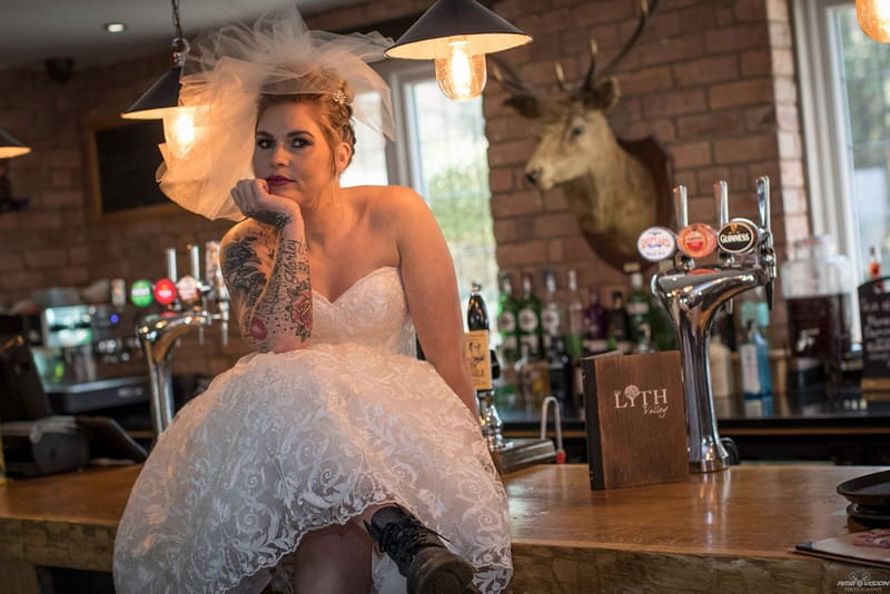 Bride sitting on bar at Lyth Valley Country Inn