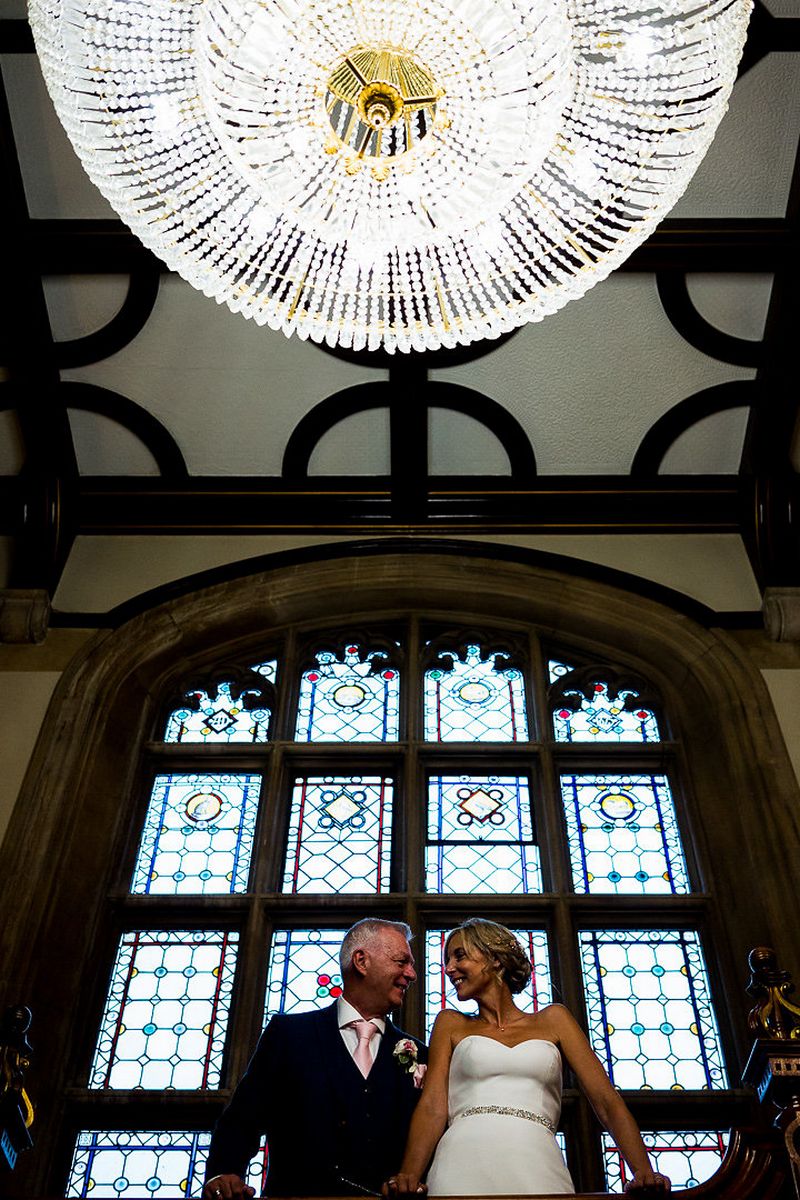 Bride and groom under chandelier at Pendley Manor