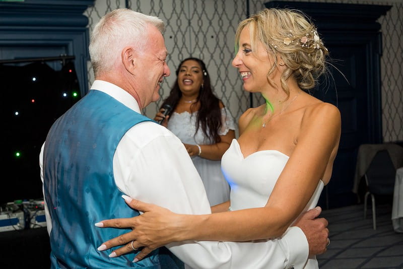 Bride and groom dancing as bride's daughter sings