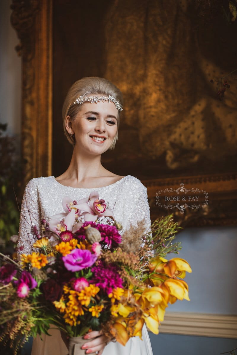 Bride holding autumnal bouquet with bright flowers