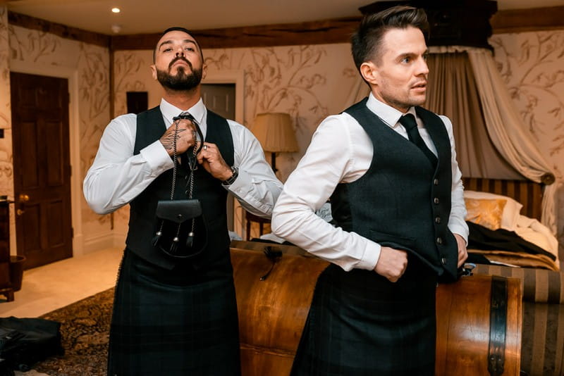 Groomsmen getting dressed into Scottish wedding attire