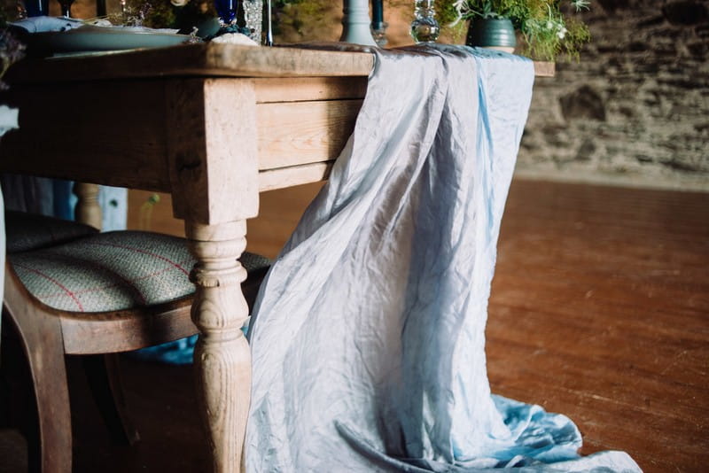 Light grey/blue linen hanging off end of wedding table