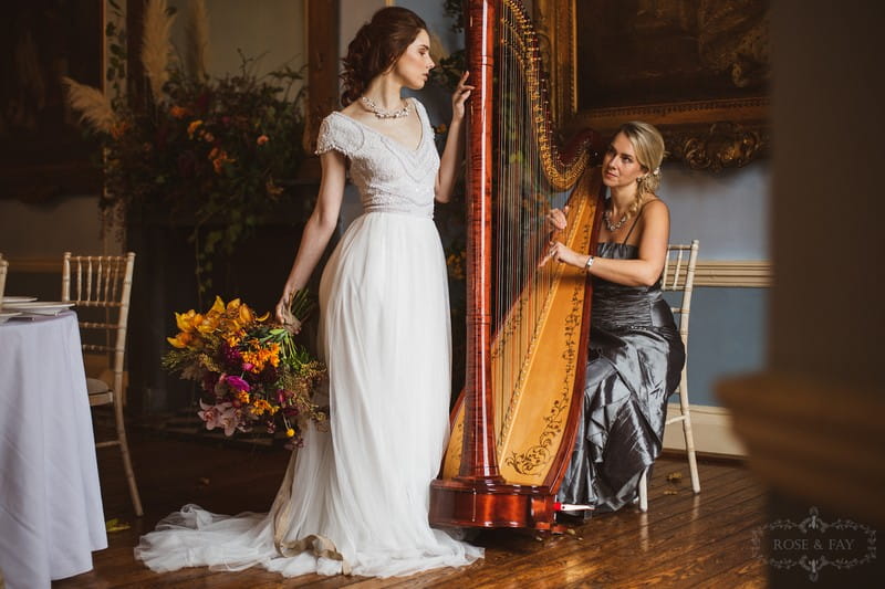 Bride standing next to wedding harpist