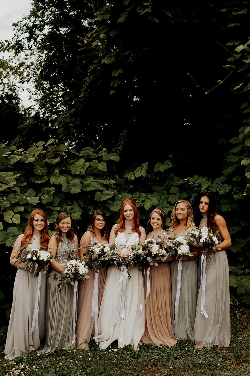Bride and bridesmaids standing in line holding bouquets