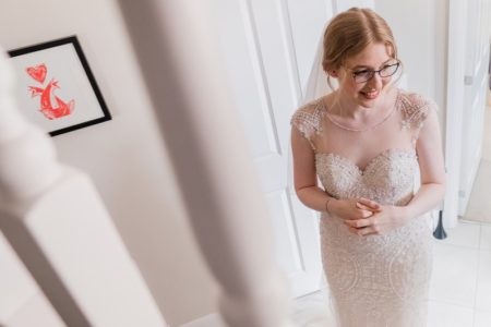 Bride with glasses standing at bottom of stairs - Picture by Simon Dewey Photography