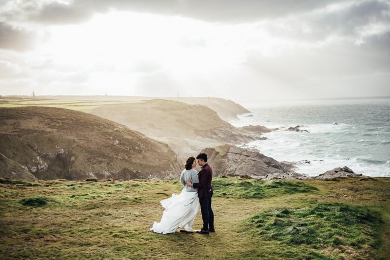 Bride and groom on top of cliff overlooking the sea - Picture by Liberty Pearl Photography