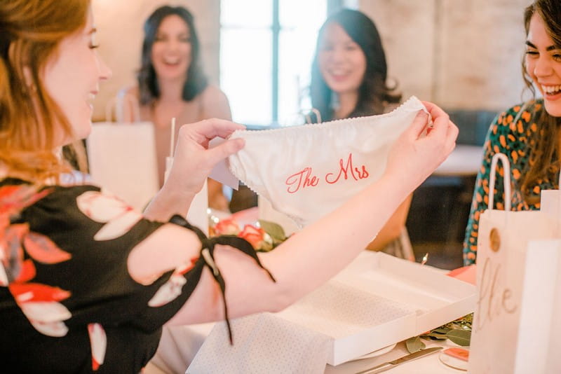 Bride-to-be holding bridal shower gift of knickers