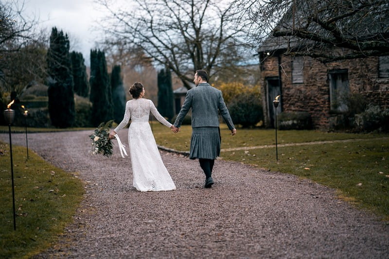 Bride and groom walking in grounds of Dewsall Court